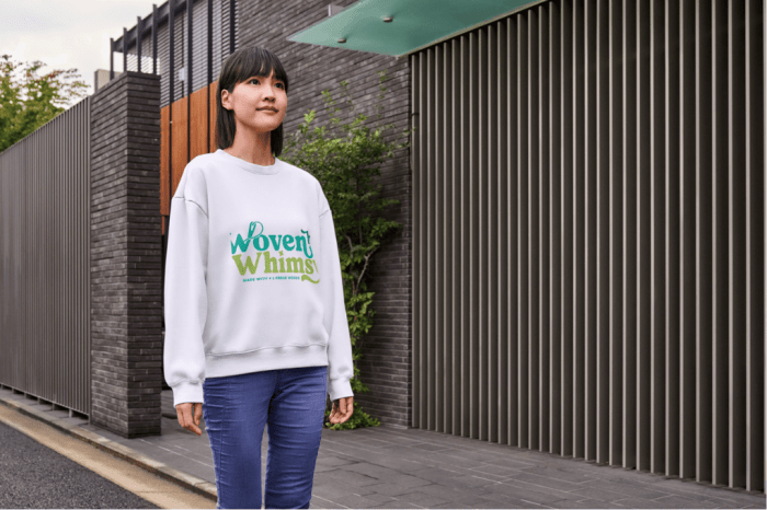 Woman in white sweatshirt with "Woven by Whimsy" text in blue and green on the front.